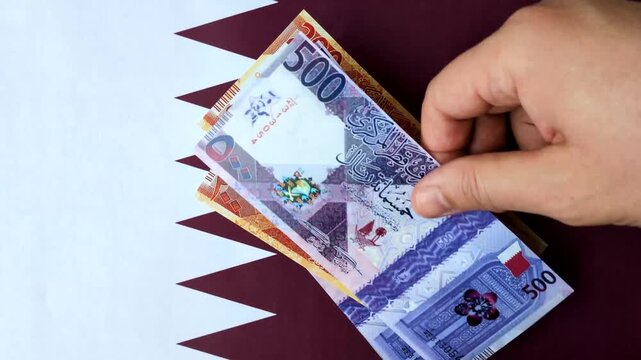 Qatar paper money, the Qatari riyal as a tool for financial transactions and trade. Qatari money as a business background for your design
