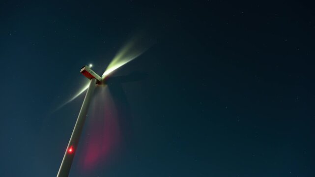 Wind Turbine Under a Starry Night Sky Timelapse. Wind turbines can generate clean, renewable energy 24 hours a day.