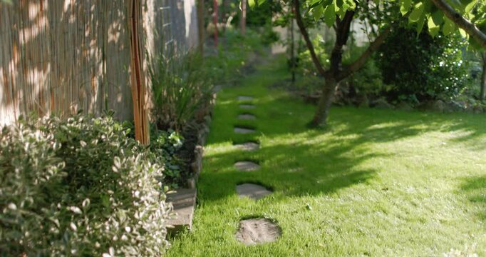 Garden pathway with stepping stones leading through lush green backyard landscape