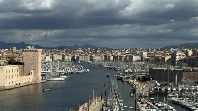 Panoramic view across the Vieux Port of Marseille with boats, waterfront buildings and the Mediterranean city skyline.