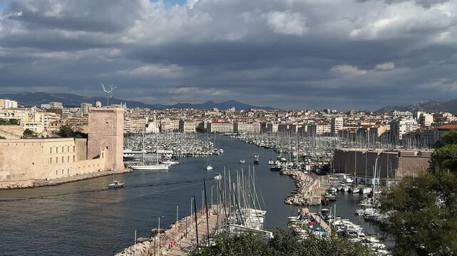 Panoramic view across the Vieux Port of Marseille with boats, waterfront buildings and the Mediterranean city skyline.