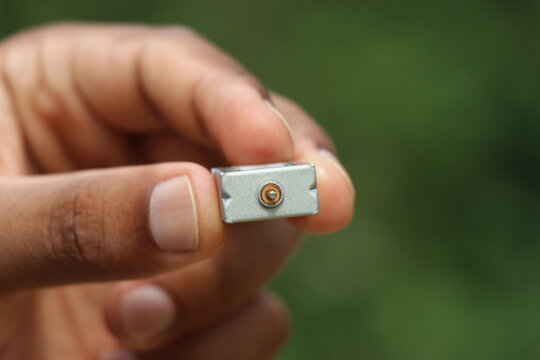 View of shaft from a metal dc motor held in the hand on natural background