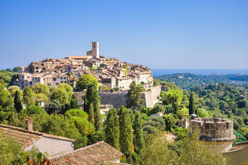 Fototapeta premium Panoramic View of Saint-Paul-de-Vence Medieval Hilltop Village Surrounded by Lush Green Trees, Provence, France
