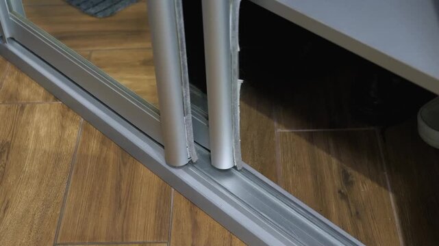 A sliding wardrobe mechanism on rails. Opening mirrored sliding wardrobe doors
