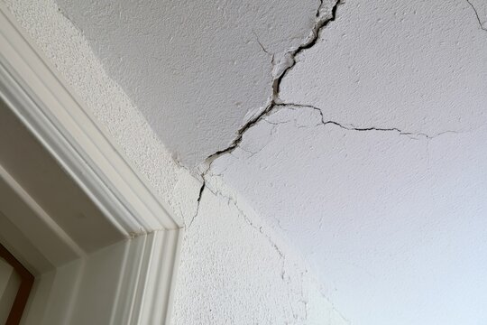 Cracked wall corner in an indoor space showing signs of wear and damage over time
