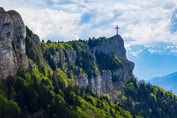 Obraz premium Panoramic view of the Croix du Nivolet overlooking the city of Chambéry from the top of its limestone cliff seen from the Alpage du Sire