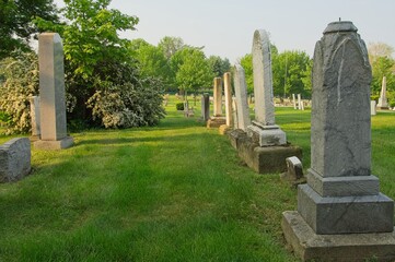 Fototapeta premium cedmetary with grave stones, monuments and grass, sunlight