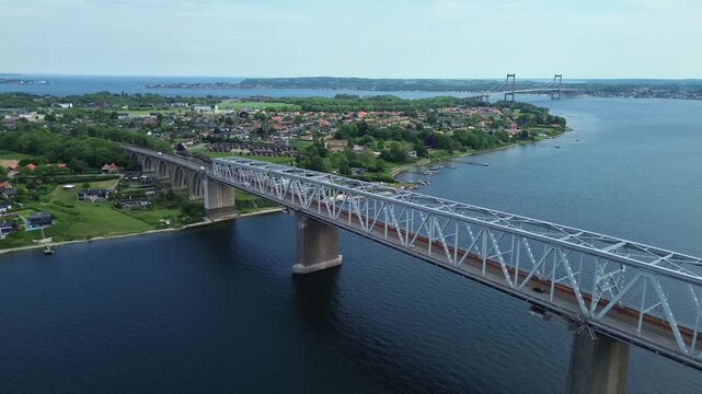 Aerial drone view of the historic Old Little Belt Bridge steel structure spanning the deep blue waters in sunny Denmark