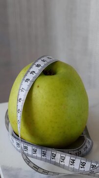 Fresh green apple with Measuring Tape for Healthy Eating and Weight Management concept.