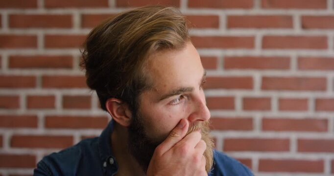 Education, face and thinking with student on brick wall background at college for inspiration. Beard, planning and vision with man on university campus for development, learning or study ideas
