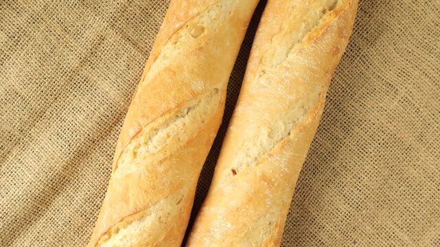 Freshly baked french baguettes rotating on jute fabric