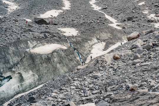 Mountaineers hiking across glacier and rocky mountain terrain