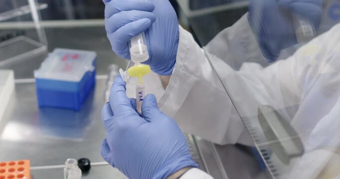 Filtration of a medicinal product using a disc filter into a small test tube. A scientist filters a medication for a patient in a laboratory.