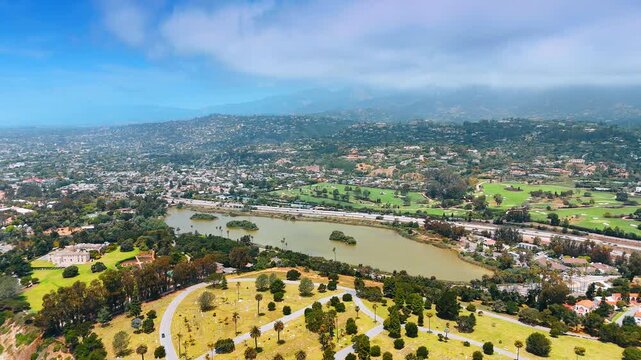 Green urban landscape near the mountains. Clouds float in the sky covering the view. Beautiful Santa Barbara, California, USA.