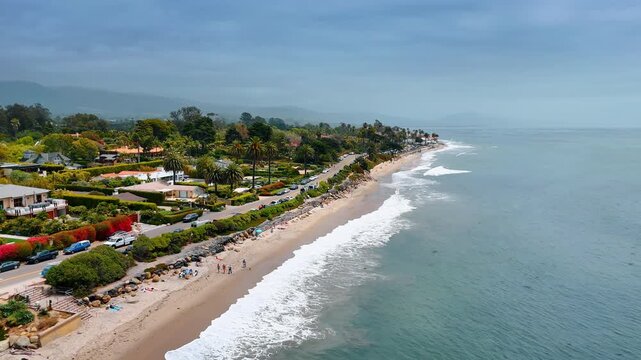 White foamy waves roll to the sandy beach. Beautiful coast of Santa Barbara, California, USA. Aerial view.