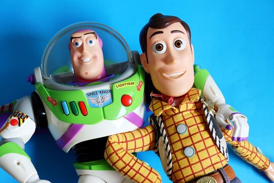 Salvador, Brazil - June 6, 2026: Sheriff Woody and Buzz Lightyear toys on a blue background. Toy Story movie and childhood toys. 