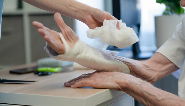 Health insurance coverage for medical bandage application procedure, close-up dressing on patient hand with treatment reimbursement plan for fracture recovery in clinical hospital setting
