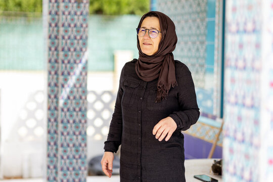 Muslim woman in hijab standing in a mosque courtyard