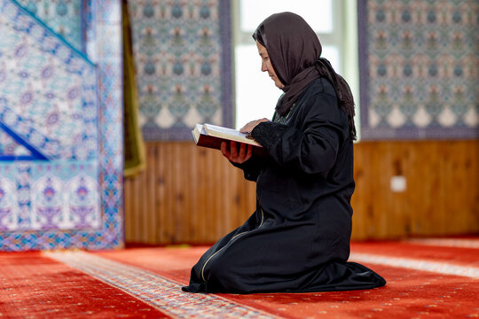 Muslim woman reading while praying inside mosque