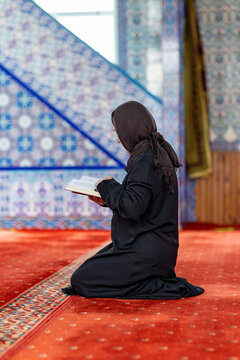 Muslim woman reading while praying inside mosque