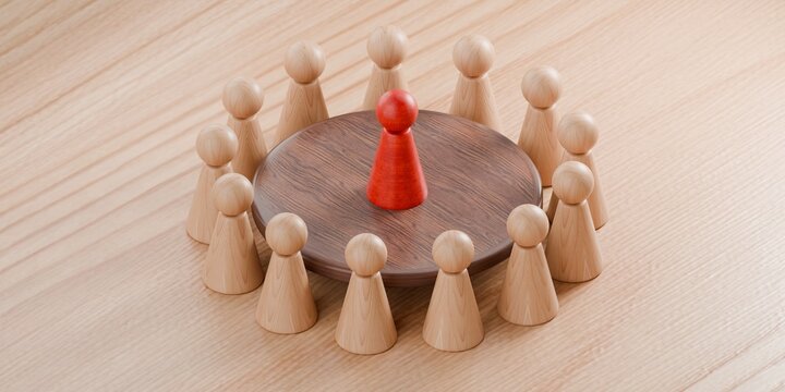 pawn figurines standing round a table, with one pawn highlighted in red. Corporate work environment, meeting, interview