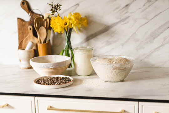 Homemade sourdough bread with ingredients on counter