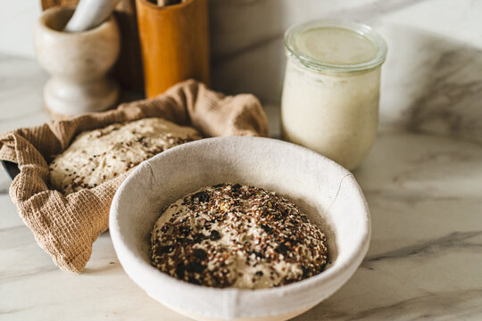 Close-up of sourdough bread dough rising with seeds