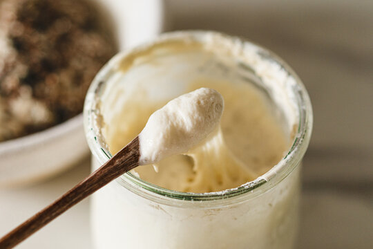 Close-up of rustic sourdough starter in glass jar