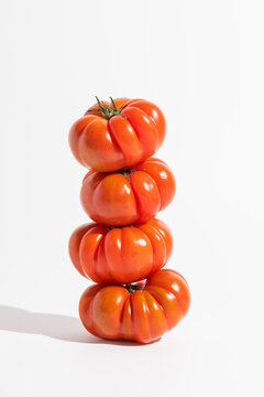 Fresh tomatoes stacked vertically with bright lighting