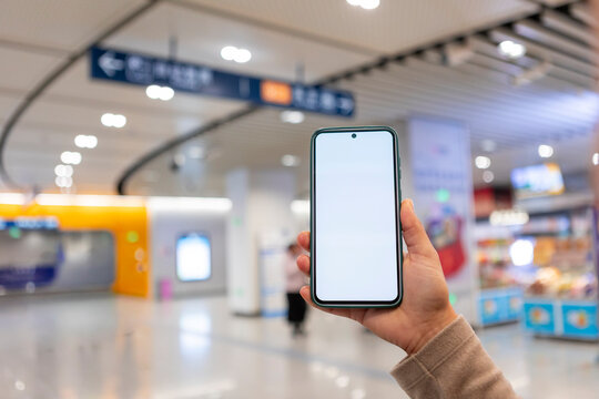 Person holding smartphone in modern subway station