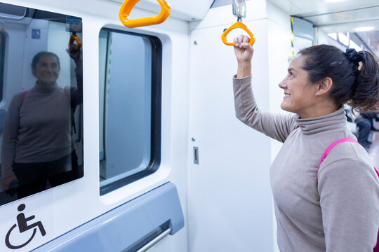 Woman smiling while standing in a subway train