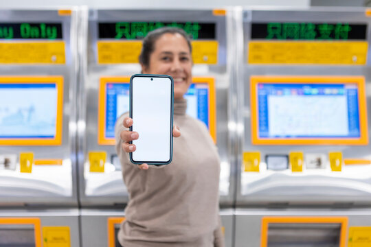 Woman showing smartphone at subway station