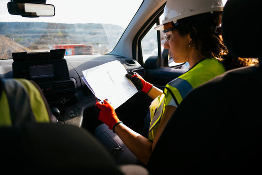 Female construction worker reviewing plans in work vehicle