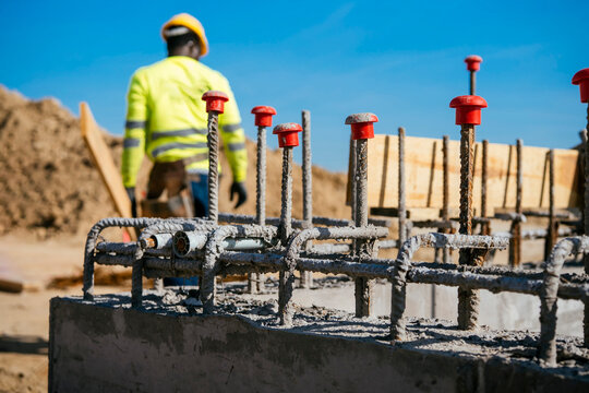 Construction worker near rebar and concrete foundation