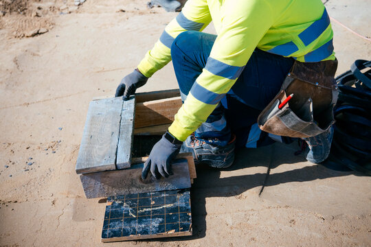 Construction worker adjusting wooden structure on site