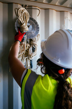 Female construction worker organizing rope and equipment