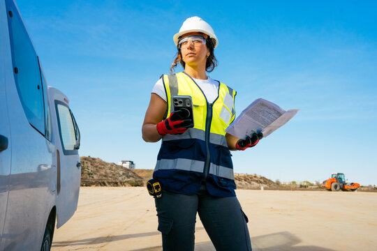 Female construction worker using smartphone on job site