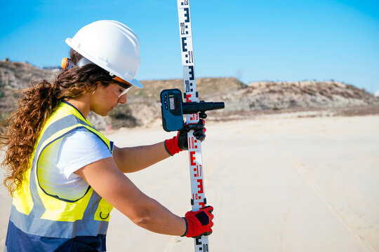 Female construction worker using survey tool at jobsite