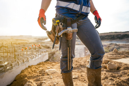 Female construction worker with tool belt at building site