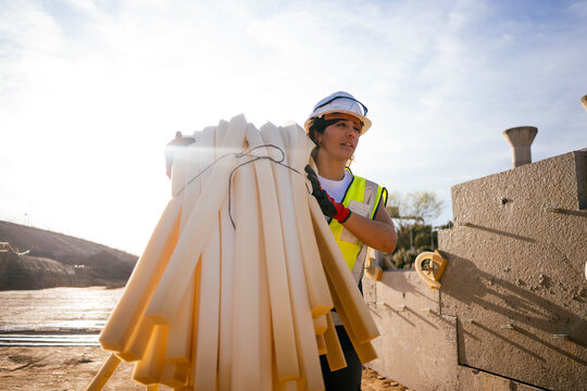 Female construction worker carrying foam insulation panels