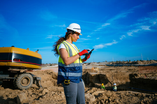 Female construction worker using phone at job site