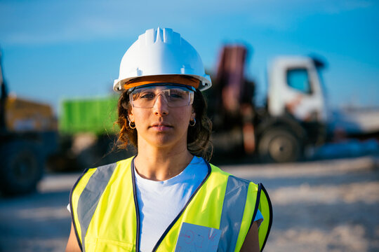 Woman construction worker in helmet with safety gear