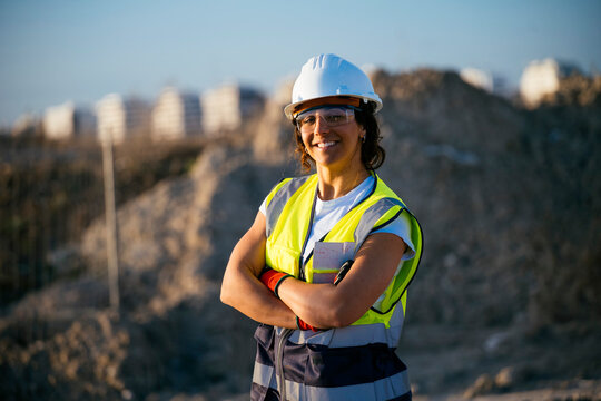 Female construction worker wearing helmet at dusty worksite
