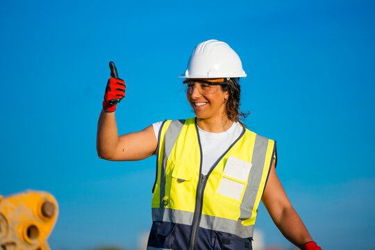 Female construction worker in helmet showing safety approval