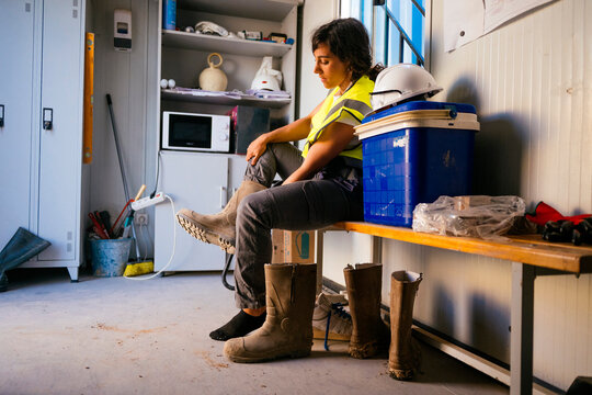Female construction worker resting in site cabin break room
