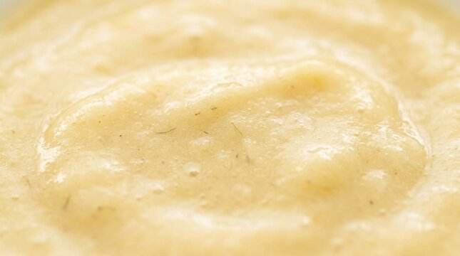 Creamy yellow hummus or corn paste texture macro.