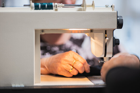 Senior woman sewing homemade garment with care
