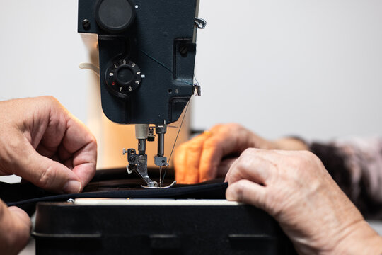 Senior hands sewing with care and precision