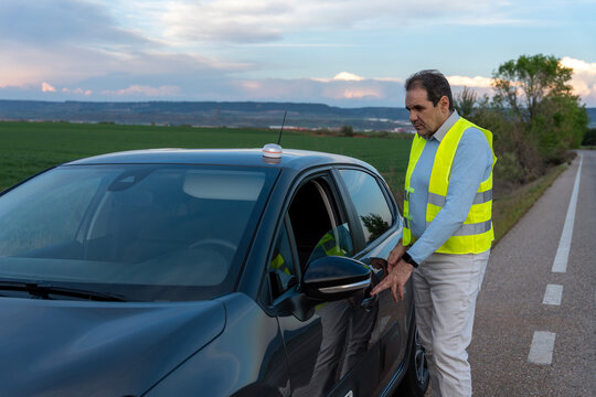 Driver using V16 emergency beacon during roadside warning