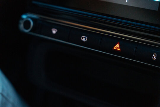Close-up of car dashboard hazard warning button at night